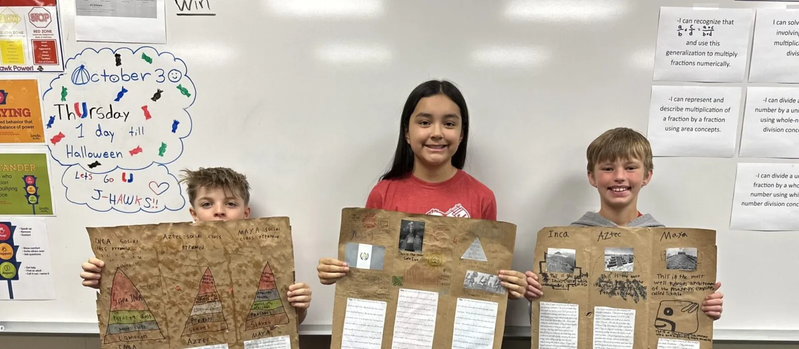 three students pose with their codices