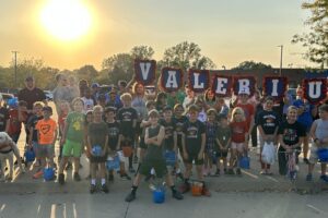 valerius students holding signs and posing for picture