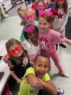 Valerius students wearing pink and red heart glasses